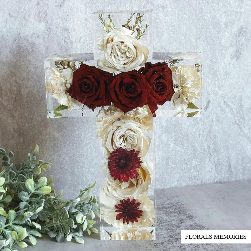 Memorial cross resin block with preserved funeral flowers in soft studio light