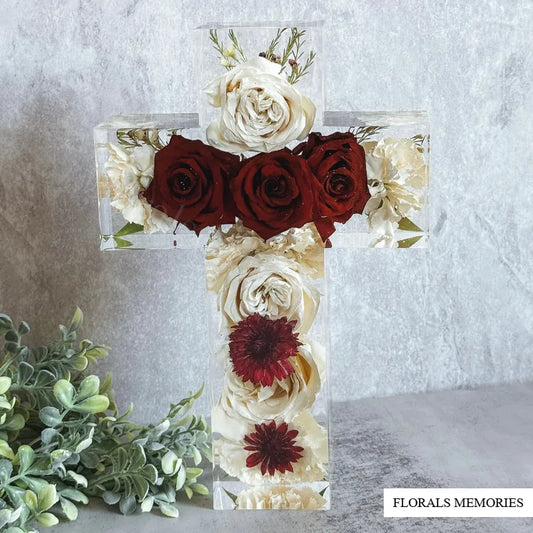 Memorial cross resin block with preserved funeral flowers in soft studio light